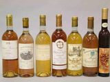 plusieurs bouteilles de vin sont alignées sur une surface blanche
