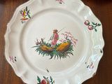 three plates on a table with a bird and flowers on them