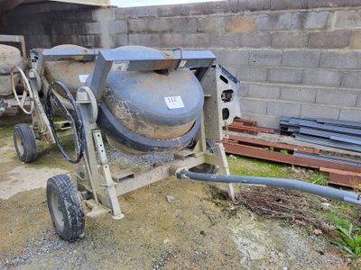 a cement mixer that is sitting on the ground