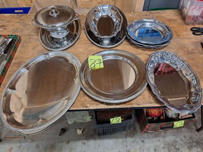une table sur laquelle sont disposées de nombreuses assiettes et bols en argent