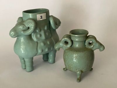 deux vases verts posés l'un à côté de l'autre sur une table