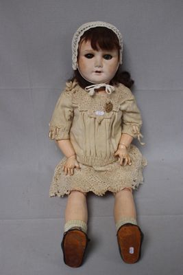 an image of a doll is sitting on the floor wearing a dress and a bonnet