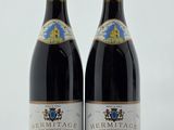 deux bouteilles de vin posées sur une table l'une à côté de l'autre