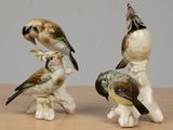 three figurines of birds sitting on top of a wooden table