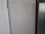 a refrigerator in the corner of a kitchen with tile on the floor