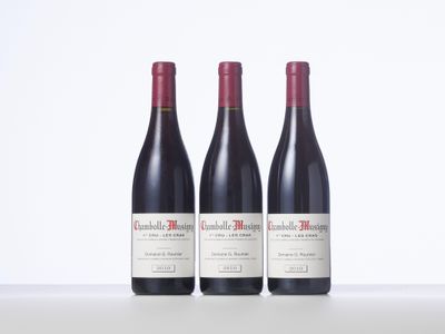 three bottles of red wine sitting on top of a table