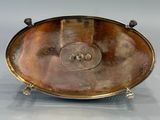 an antique silver plate with a button on it on a stand