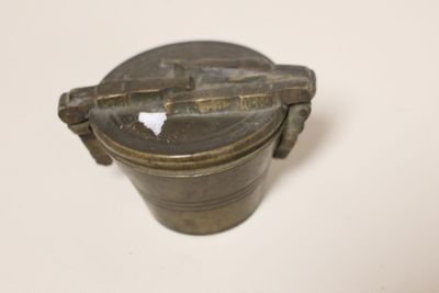 an old metal container sitting on top of a white table