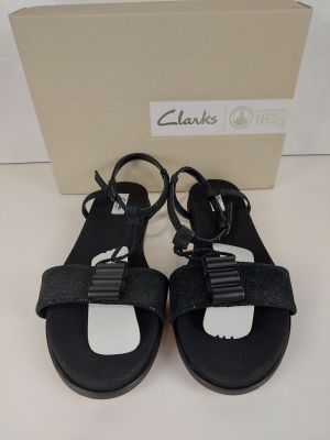 les sandales noires de Clark, avec des semelles blanches et des lanières noires
