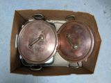 two pots and pans in a box on the floor