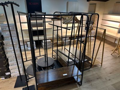 a metal rack with a clock on it in the middle of a room