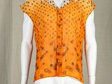 an image of a mannequin wearing an orange shirt with polka dots on it