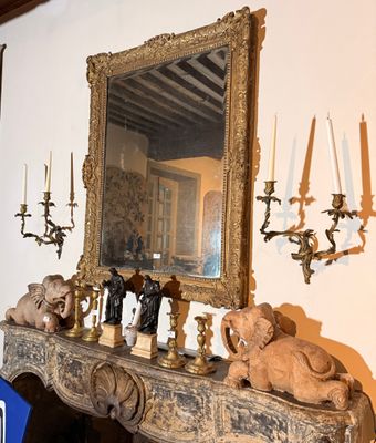 une cheminée sur laquelle sont posées des bougies et un miroir