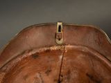 a close up of a brown leather hat with a metal buckle