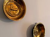 two gold bowls on the wall next to each other