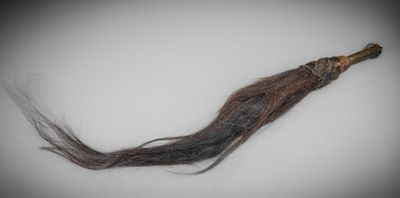 une longue mèche de cheveux bruns posée sur une table