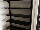une étagère en noir et blanc avec des tablettes dans une pièce