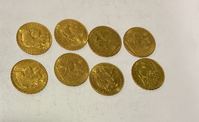 a close up of a bunch of gold coins on a white surface