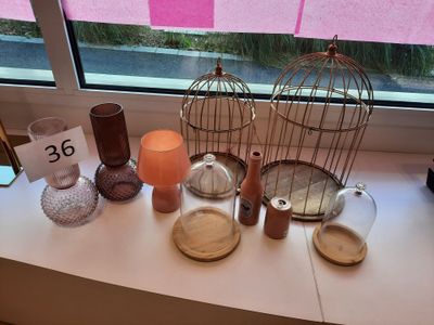 une cage à oiseaux sur laquelle est inscrit un numéro, près d'une fenêtre