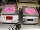 deux balances électroniques posées sur le comptoir, sur lesquelles sont posés des billets roses