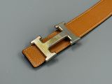 buckle of a brown leather belt on a gray surface