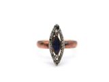 a close up of a ring with a blue sapphire and diamonds