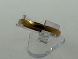 a ring with a gold band sitting on top of a clear object