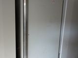 two refrigerators that are sitting in a room