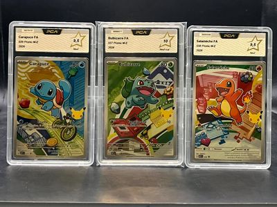 trois cartes à collectionner Pokémon exposées dans une vitrine