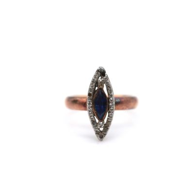 a close up of a ring with a blue sapphire and diamonds