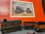 three toy trains on a table with a picture on the wall