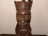 une statue représentant un homme coiffé d'une couronne, posée sur une table en bois