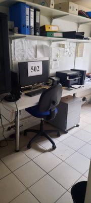 un bureau d'ordinateur sur lequel sont posés deux écrans et une imprimante