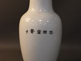 a white vase with chinese writing on it sitting on a table