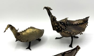 trois morceaux de métal posés sur une surface blanche