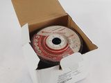 une boîte ouverte contenant un disque, posée sur une surface blanche