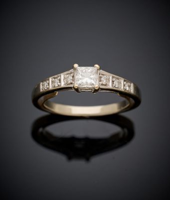 une bague de fiançailles ornée de trois diamants taille princesse sur un fond noir
