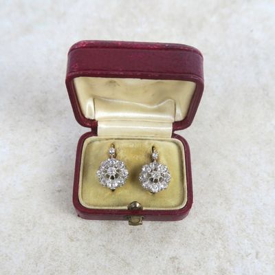 a pair of earrings in a red box on a white surface