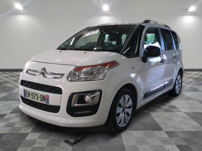 la petite camionnette blanche est garée sur un carrelage à carreaux