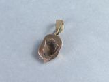 silver and gold plated pendant with a face of a rock