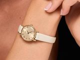 the woman is wearing a white watch and a white bracelet