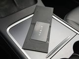 a cell phone and a pen in the center console of a car