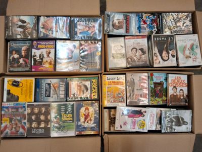 un grand nombre de dvd dans une boîte posée sur le sol