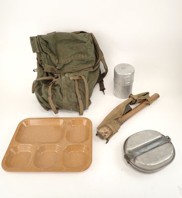 a backpack, a lunch box, and a can of soda sitting on a table