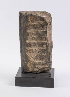 a close up of a stone block on a black stand
