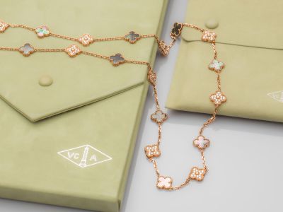 deux bijoux posés sur une table, à côté d'une boîte verte