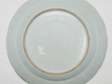 a white plate with a brown rim on a white table