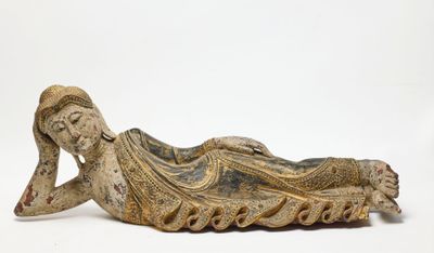 une vieille statue représentant une femme allongée sur le dos sur une surface blanche