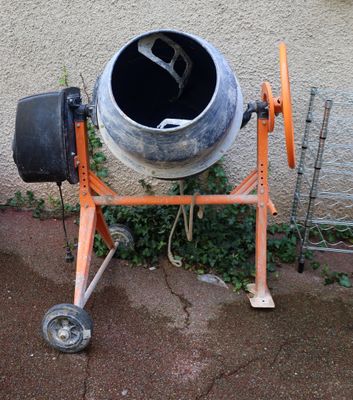a cement mixer sitting outside on the sidewalk