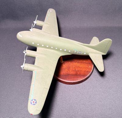 une petite maquette d'avion posée sur un socle en bois